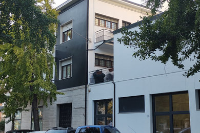 Esempio della facciata di una casa bianca contemporanea a tre piani con abbinamento di colori