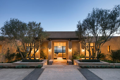 Inspiration for a large southwestern beige one-story adobe flat roof remodel in Santa Barbara