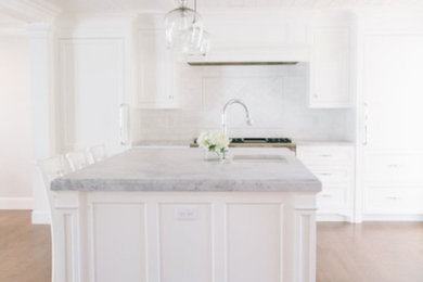 Elegant medium tone wood floor and shiplap ceiling open concept kitchen photo in Salt Lake City with a drop-in sink, shaker cabinets, white cabinets, white backsplash, subway tile backsplash, paneled appliances, an island and gray countertops