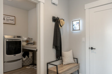 Example of a mid-sized trendy l-shaped brown floor dedicated laundry room design in Other with a side-by-side washer/dryer and beige countertops