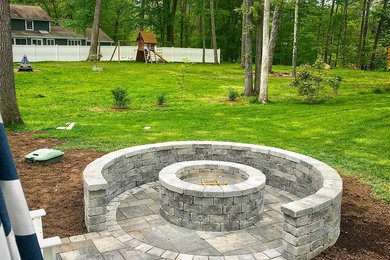 Design ideas for a backyard brick landscaping in Other with a fire pit.