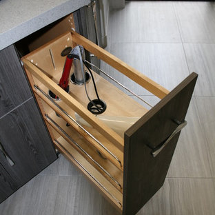 Inspiration pour une grande douche en alcôve principale minimaliste avec un placard à porte plane, des portes de placard grises, un carrelage gris, un plan de toilette en terrazzo, une baignoire posée, un WC à poser, un carrelage de pierre, un mur beige, un sol en carrelage de porcelaine, un lavabo encastré, un sol gris et une cabine de douche à porte battante.