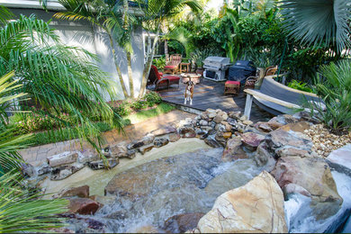 This is an example of a large backyard stone landscaping in Tampa.