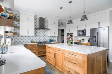Eat-in kitchen - mid-sized farmhouse medium tone wood floor and brown floor eat-in kitchen idea in Other with a farmhouse sink, shaker cabinets, white cabinets, quartz countertops, blue backsplash, porcelain backsplash, stainless steel appliances, an island and white countertops