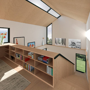 Inredning av ett modernt mellanstort hemmastudio, med vita väggar, plywoodgolv, ett inbyggt skrivbord och brunt golv