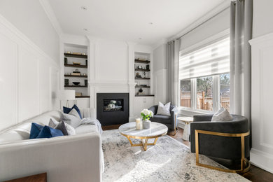 Transitional formal and enclosed medium tone wood floor and brown floor living room photo in Toronto with white walls, a standard fireplace and no tv