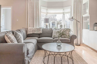 Danish light wood floor living room photo in Toronto with gray walls, a corner fireplace, a stone fireplace and a wall-mounted tv