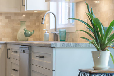 Example of a classic l-shaped medium tone wood floor and brown floor open concept kitchen design in Montreal with a double-bowl sink, white cabinets, beige backsplash, stainless steel appliances and an island