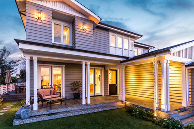 This is an example of a coastal tile front porch design in Los Angeles with a roof extension.