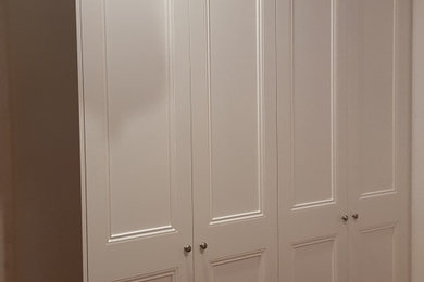 This is an example of a traditional gender-neutral built-in wardrobe in Melbourne with white cabinets.
