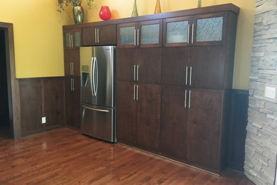 Example of a large trendy u-shaped medium tone wood floor open concept kitchen design in Columbus with an undermount sink, flat-panel cabinets, brown cabinets, quartzite countertops, white backsplash, ceramic backsplash, stainless steel appliances and a peninsula