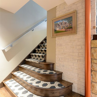 Small midcentury look-out basement in Other with beige walls, medium hardwood flooring, a standard fireplace, a stone fireplace surround and beige floors.