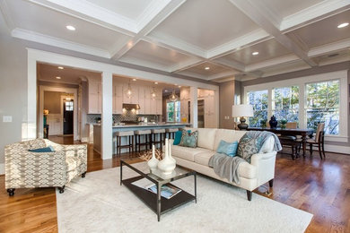 Living room - mid-sized transitional open concept medium tone wood floor living room idea in Raleigh with gray walls, a standard fireplace, a wall-mounted tv and a tile fireplace