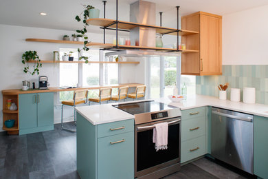 Mid-sized 1950s u-shaped vinyl floor and gray floor eat-in kitchen photo in Atlanta with an undermount sink, flat-panel cabinets, medium tone wood cabinets, quartz countertops, green backsplash, ceramic backsplash, stainless steel appliances, a peninsula and white countertops
