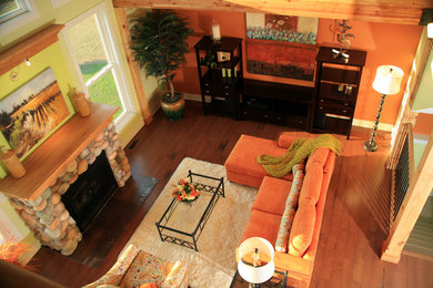 Inspiration for a mid-sized timeless open concept medium tone wood floor living room remodel in Other with a standard fireplace and a stone fireplace