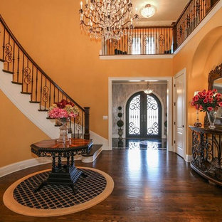 Inredning av en klassisk stor hall, med orange väggar, mörkt trägolv och brunt golv