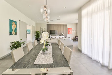 Contemporary open plan dining in Miami with beige walls, porcelain floors and grey floor.