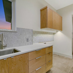 Inspiration for a large modern u-shaped utility room in Austin with a submerged sink, flat-panel cabinets, medium wood cabinets, engineered stone countertops, white walls, porcelain flooring, a side by side washer and dryer, multi-coloured floors and turquoise worktops.