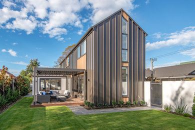 This is an example of a mid-sized modern two-storey black house exterior in Christchurch with metal siding and a metal roof.