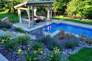 Inspiration for a large contemporary partial sun backyard concrete paver landscaping in Toronto.