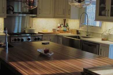 Inspiration for a mid-sized timeless l-shaped medium tone wood floor and brown floor enclosed kitchen remodel in Richmond with an undermount sink, beaded inset cabinets, white cabinets, wood countertops, white backsplash, stainless steel appliances and an island