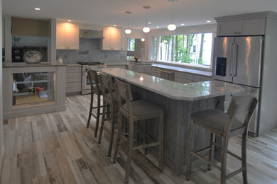 Inspiration for a mid-sized rustic l-shaped porcelain tile kitchen remodel in New York with a farmhouse sink, gray cabinets, granite countertops, blue backsplash, stainless steel appliances and an island
