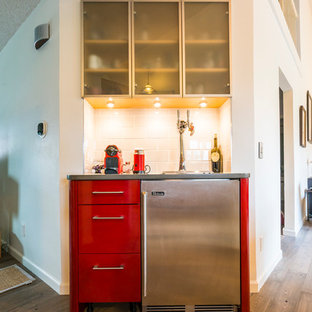 デンバーの小さいコンテンポラリースタイルのおしゃれなウェットバー (フラットパネル扉のキャビネット、赤いキャビネット、クオーツストーンカウンター、白いキッチンパネル、サブウェイタイルのキッチンパネル、無垢フローリング、茶色い床、グレーのキッチンカウンター) の写真