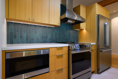 Example of a small 1960s galley porcelain tile, gray floor and exposed beam eat-in kitchen design in Seattle with an undermount sink, flat-panel cabinets, light wood cabinets, quartz countertops, blue backsplash, porcelain backsplash, stainless steel appliances, an island and white countertops