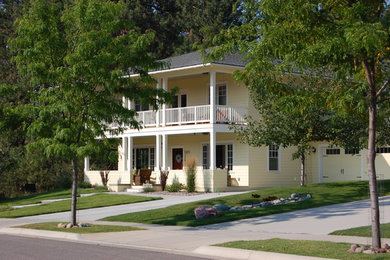 Traditional yellow two-story wood exterior home idea in Other