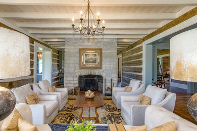 This is an example of a country formal living room in Nashville with brown walls, medium hardwood floors, a standard fireplace and a stone fireplace surround.