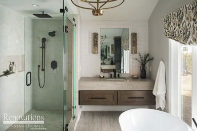 Inspiration for a mid-sized transitional master white tile and subway tile double-sink, porcelain tile, beige floor and vaulted ceiling bathroom remodel in Kansas City with shaker cabinets, medium tone wood cabinets, a floating vanity, a one-piece toilet, beige walls, an undermount sink, granite countertops, a hinged shower door, beige countertops and a niche