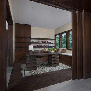 This is an example of a medium sized modern study in Detroit with green walls, dark hardwood flooring, a freestanding desk and brown floors.