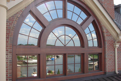 Example of a huge classic red three-story brick house exterior design in New York with a hip roof and a shingle roof