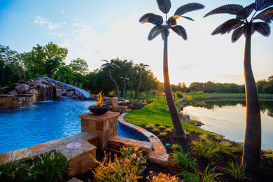 Huge island style backyard pool photo in Kansas City