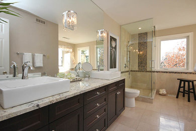 Large transitional master beige tile and marble tile marble floor and beige floor bathroom photo in Ottawa with shaker cabinets, dark wood cabinets, a one-piece toilet, beige walls, a vessel sink, granite countertops and a hinged shower door