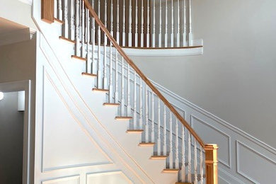 Modelo de escalera curva tradicional grande con escalones de madera, contrahuellas de madera y barandilla de madera