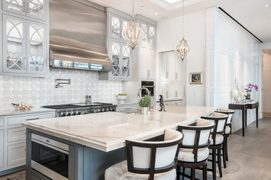 Inspiration for a mid-sized transitional galley light wood floor and gray floor open concept kitchen remodel in Austin with a farmhouse sink, shaker cabinets, white backsplash, stainless steel appliances, an island, white countertops, quartzite countertops, mosaic tile backsplash and gray cabinets