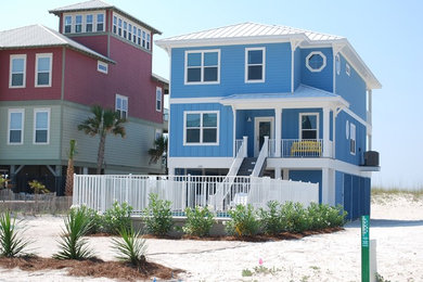 Large beach style blue two-story vinyl exterior home photo in Miami with a hip roof