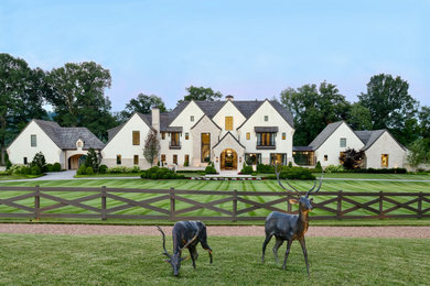 Photo of a huge french country partial sun front yard concrete paver and wood fence landscaping for summer.