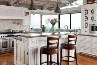 Photo of a contemporary galley eat-in kitchen in Los Angeles with an undermount sink, glass-front cabinets, white cabinets, quartzite benchtops, glass tile splashback and stainless steel appliances.