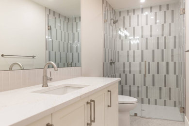 Doorless shower - small contemporary 3/4 multicolored tile and ceramic tile single-sink doorless shower idea in Calgary with a two-piece toilet, an integrated sink, solid surface countertops, a hinged shower door, white countertops and a floating vanity