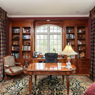 Foto på ett mellanstort vintage arbetsrum, med ett bibliotek, röda väggar, mellanmörkt trägolv, ett fristående skrivbord och flerfärgat golv