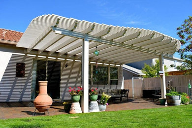 Example of a mid-sized classic backyard brick patio design in Other with a fire pit and a pergola
