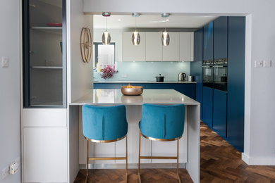 Imagen de cocina comedor contemporánea con fregadero integrado, armarios con paneles lisos, puertas de armario azules, encimera de cuarcita y electrodomésticos con paneles