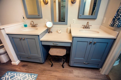 Example of a mid-sized transitional master white tile and stone slab medium tone wood floor and brown floor bathroom design in Orlando with blue cabinets, white walls, shaker cabinets, a two-piece toilet, an undermount sink and solid surface countertops