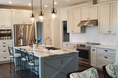 Example of a mid-sized beach style eat-in kitchen design in Miami with shaker cabinets, white cabinets, quartz countertops, white backsplash, an island and white countertops