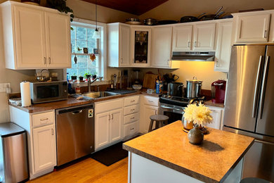 ボストンにある高級な中くらいなモダンスタイルのおしゃれなキッチン (ドロップインシンク、インセット扉のキャビネット、白いキャビネット、木材カウンター、シルバーの調理設備、無垢フローリング、板張り天井) の写真