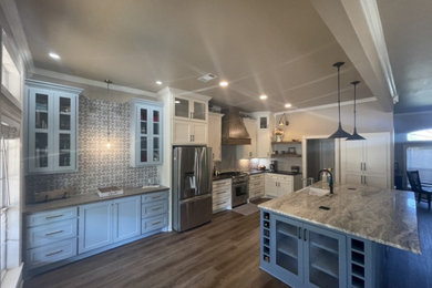 Kitchen - contemporary vinyl floor and brown floor kitchen idea in Austin with a farmhouse sink, shaker cabinets, blue cabinets, granite countertops, gray backsplash, porcelain backsplash, stainless steel appliances, an island and gray countertops
