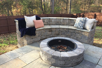 Example of a large classic backyard stone patio design in Other with a fire pit and no cover