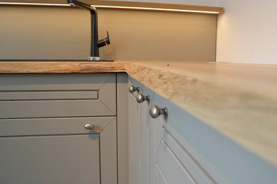 Geschlossene, Große Nordische Küche ohne Insel in U-Form mit Waschbecken, profilierten Schrankfronten, grauen Schränken, Arbeitsplatte aus Holz, Küchenrückwand in Beige und Rückwand aus Holz in Nürnberg